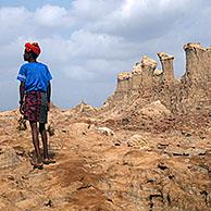 Black man of the Afar tribe and towers and pinnacles composed of salt, potassium and magnesium in the Danakil Desert, Ethiopia, Africa