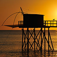 Traditional carrelet fishing hut with lift net on the beach at sunset, Loire-Atlantique, France