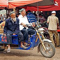 Uyghur farmers with motorized cart loaded with sheep at the cattle market in Kashgar / Kashi, Xinjiang, China