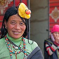 Portrait of Tibetan Khampa woman wearing traditional amber and red coral hair piece at Zhuqing, Sichuan Province, China
