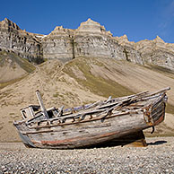 Wooden wrecked fishing boat stranded on shingle beach of Skansbukta, Svalbard, Spitsbergen