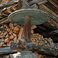 Detail of traditional wooden granary / raccard showing a circular stone slab to prevent rodents from gaining access to the grain or fodder reserves, Valais, Switzerland