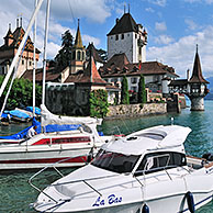 Pleasure boats and the castle of Oberhofen along the Tunersee / Lake Thun in the Bernese Alps, Switzerland