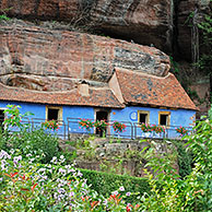 The blue troglodyte houses in rock face at Graufthal, Vosges, Alsace, France